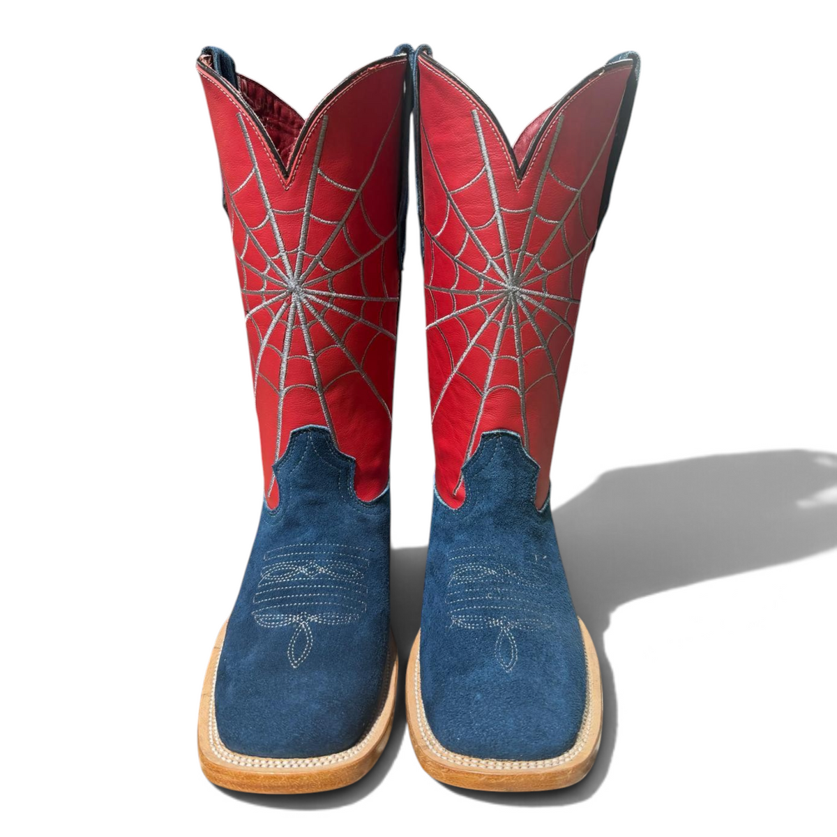 Cowboy City Western Wear blue suede cowboy boots with red shafts featuring silver spiderweb stitching and square toes.