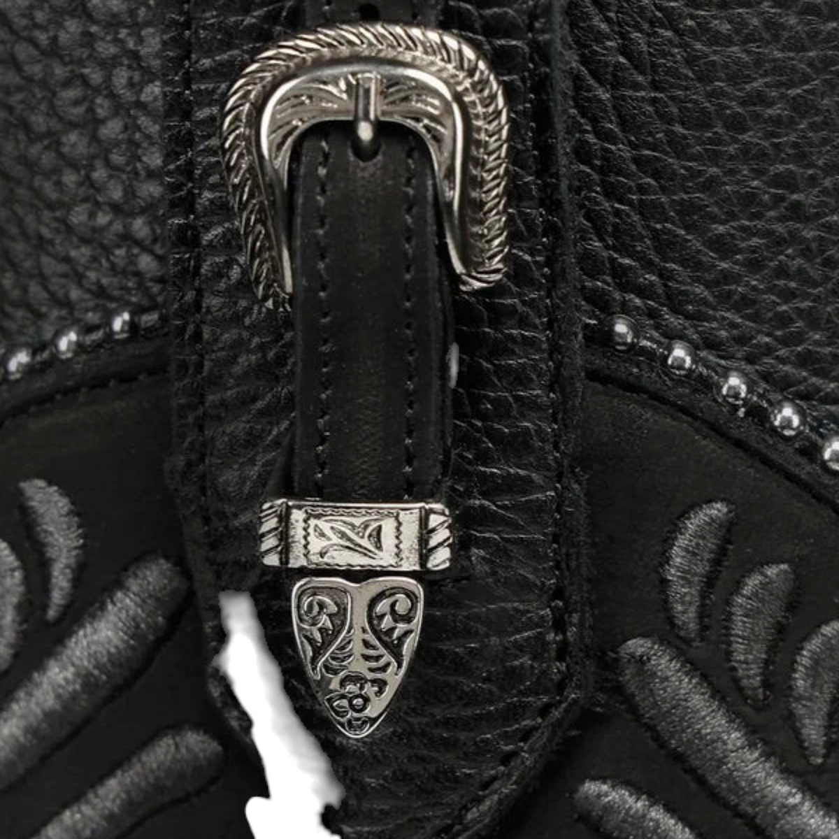 Cowboy City Western Wear black leather knee-high boot detail featuring silver buckle hardware and relief embroidery